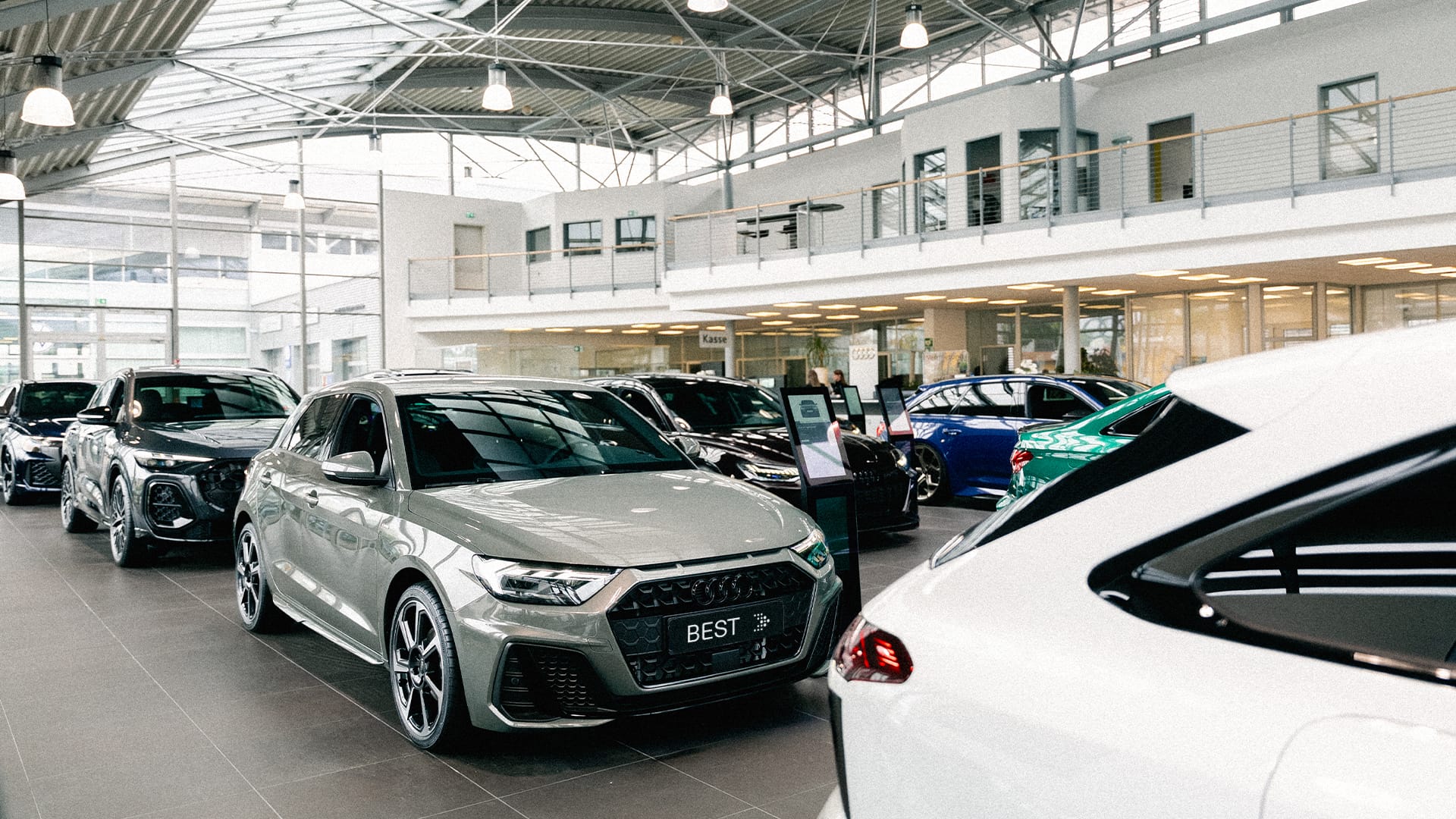 Eine Innenaufnahme des Audi Autohauses in Mühlheim am Main, die den Showroom und einige Audi Modelle zeigt.